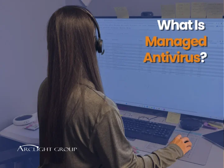 Female ArcLight employee working at a desk with text reading"What is Managed Antivirus?" in the right corner.